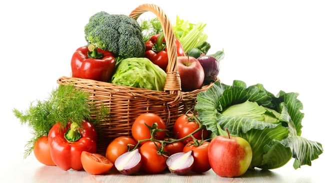 Composition with raw vegetables and wicker basket isolated on white